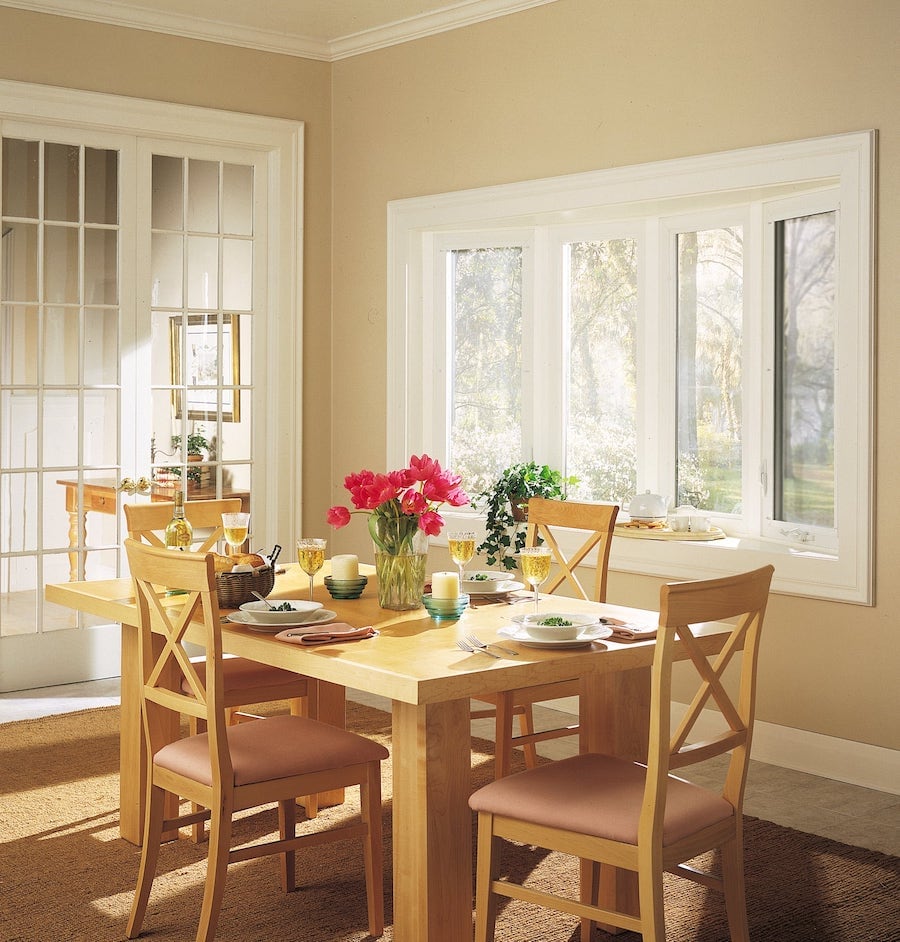 Light streams into dining room from bay and bow window.